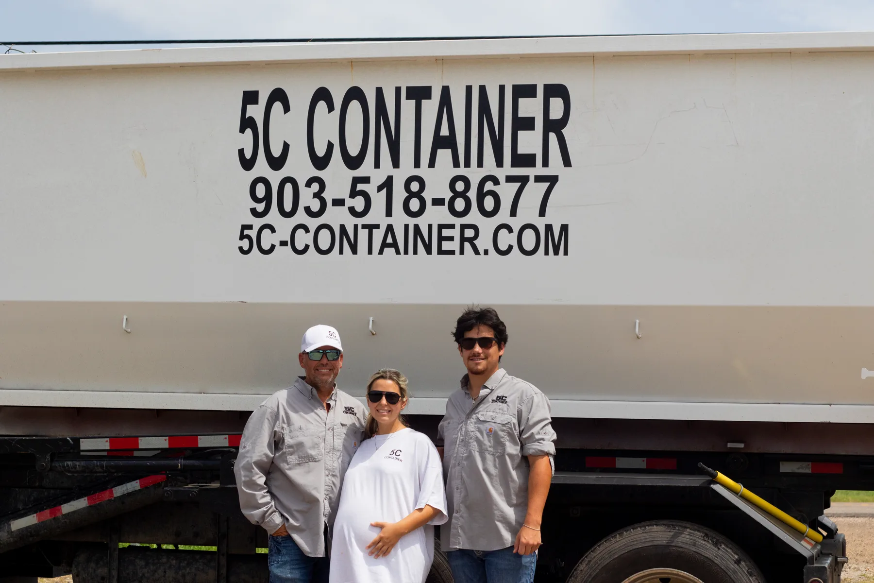 Ryan, Lexi, and John Warden beside a 5C Container roll-off truck